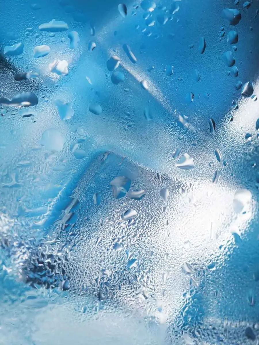 Water droplets and melting ice on a clear surface